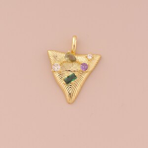 May include: Gold triangle pendant with a textured surface and colorful gemstones. The pendant features green, purple, and white stones.
