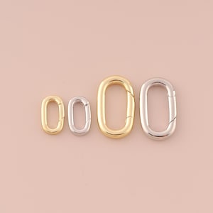 May include: Four oval-shaped metal clasps in different sizes. The clasps are silver and gold.