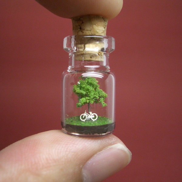 A tree and a white bike in a tiny bottle