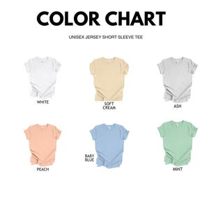 May include: Color chart showing different t-shirt colors: white, soft cream, ash, baby blue, peach, and mint. Unisex jersey short sleeve tee.
