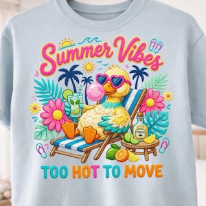 May include: Light blue t-shirt with a colorful graphic. The design features a cartoon duck wearing heart-shaped sunglasses, blowing a bubble, and relaxing on a beach chair. Text reads "Summer Vibes" and "Too Hot To Move".
