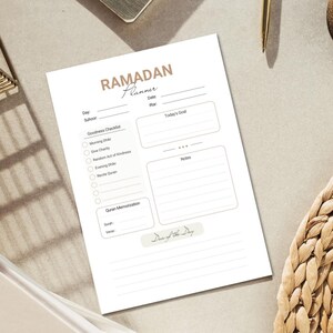May include: A printable Ramadan planner with a brown and white colour scheme. The planner includes sections for daily goals, goodness checklist, Quran memorization, and a "Dawn of the Day" section.