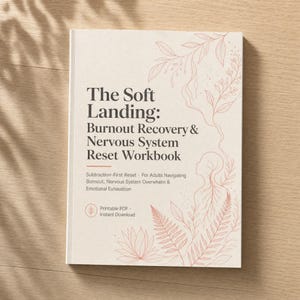 May include: A softcover workbook titled "The Soft Landing: Burnout Recovery & Nervous System Reset Workbook." The cover is off-white with a floral design in a muted pink. The book's subtitle reads "Subtraction-First Reset."
