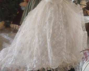 May include: A white lace wedding dress with a sweetheart neckline and short sleeves. The dress is on a mannequin and has a full skirt.
