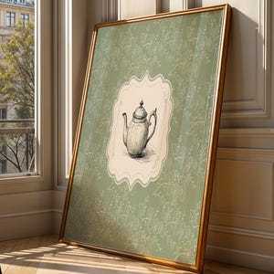 May include: A framed rectangular wall art piece featuring a sage green background with a delicate white floral pattern. In the center, a cream-colored scalloped label displays a detailed black and white sketch of a classic teapot with a lid.