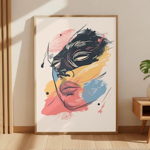 May include: Abstract art print depicting a stylized face with a black mask and colourful brushstrokes in pink, yellow, and blue. The artwork is framed in a light wood frame and leans against a neutral wall.