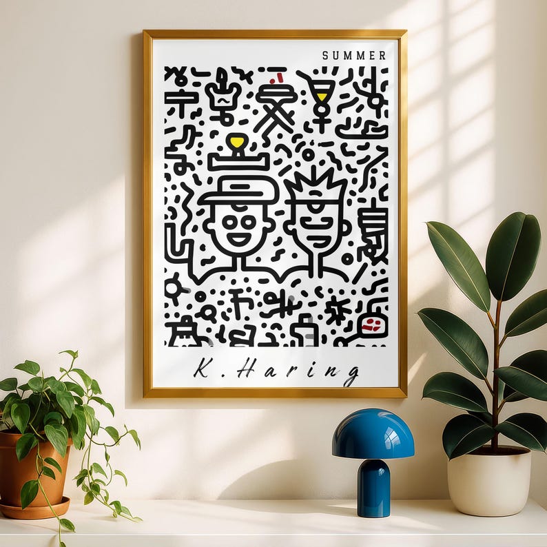 May include: A framed art print with a gold frame featuring a black and white illustration by K. Haring. The artwork includes two figures and various abstract shapes, with the word "SUMMER" at the top. A blue lamp and plants are on the shelf below.