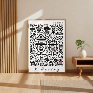 May include: A framed art print featuring a black and white illustration with the word "SUMMER" at the top. The artwork includes two cartoon figures and various abstract shapes. The artist's signature, "K. Haring," is at the bottom.