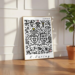 May include: A framed art print featuring a black and white illustration with the word "SUMMER" at the top and the artist's signature "K. Haring" at the bottom. The artwork depicts two figures and various abstract shapes.