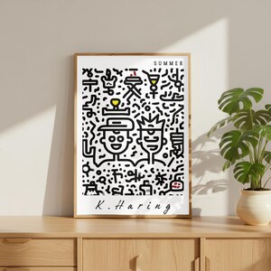 May include: A framed art print featuring a black and white Keith Haring-style illustration with the word "SUMMER" at the top. The artwork depicts two figures and various symbols. The artist's signature, "K. Haring," is at the bottom.
