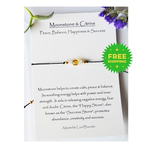May include: A black string bracelet with moonstone and citrine beads. The bracelet is on a white card with the text "Moonstone & Citrine, Peace, Balance, Happiness & Success" and "Free Shipping".