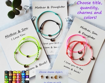 May include: Three sets of friendship bracelets with different colored cords and charms. The bracelets are labeled with the text "Mother & Son I Love You", "Mother & Daughter", and "Mother, Son & Daughter". The charms include a crescent moon, a star, and a cross. The text "Choose charm style/s in silver or gold" is also visible.