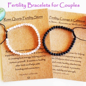 May include: Two fertility bracelets for couples. One bracelet is made with white rose quartz stones and the other is made with black lava stones. The bracelets are on brown cards with text that reads "Rose Quartz Fertility Stone" and "Fertility, Courage & Calmness Stone - Resonates w/ the Root Chakra".