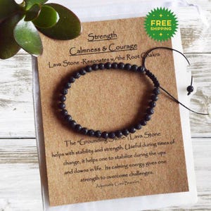 May include: Black lava stone beaded bracelet on a brown card with the text "Strength Calmness & Courage Lava Stone-Resonates w/the Root Chakra The "Grounding Stone"; Lava Stone helps with stability and strength. Useful during times of change, it helps one to stabilize during the ups and downs in life. Its calming energy gives one strength to overcome challenges. Adjustable Cord Bracelet,"
