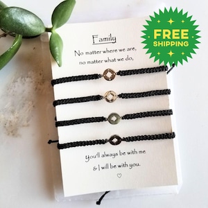 May include: Four black woven bracelets with a silver compass charm are displayed on a white card. The card reads "Family" and includes text about togetherness. A green starburst graphic with "FREE SHIPPING" is visible.