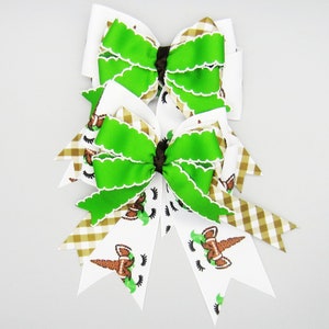 set of 2 hair bows with unicorn outline in football colors.  Green, brown gingham ribbon to accent.