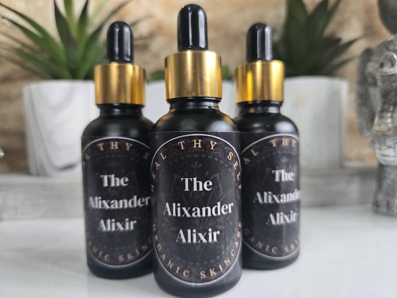 May include: Three glass bottles with gold caps and black labels. The labels say "The Alixander Alixir" and "Healthy Skin".