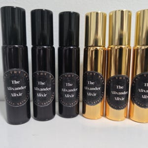 May include: Six black and gold glass bottles with roll-on applicators. Each bottle has a black label with white text that reads "The Alixander Alixir".