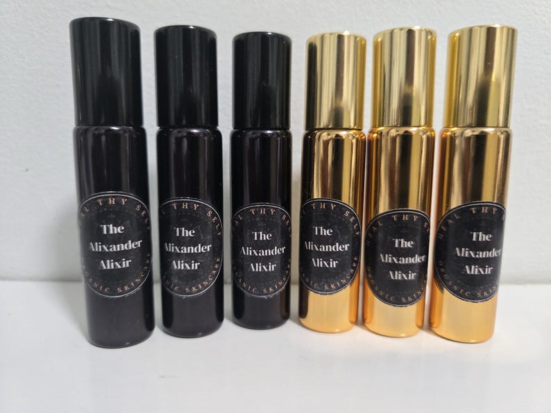 May include: Six black and gold glass bottles with roll-on applicators. Each bottle has a black label with white text that reads "The Alixander Alixir".
