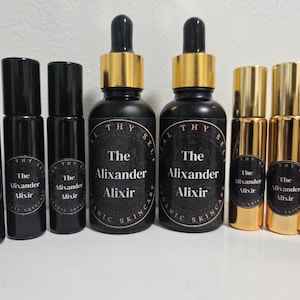 May include: A set of ten 10 ml glass bottles with gold lids. The bottles are labeled "The Alixander Alixir" and "The Mixander Mixir".