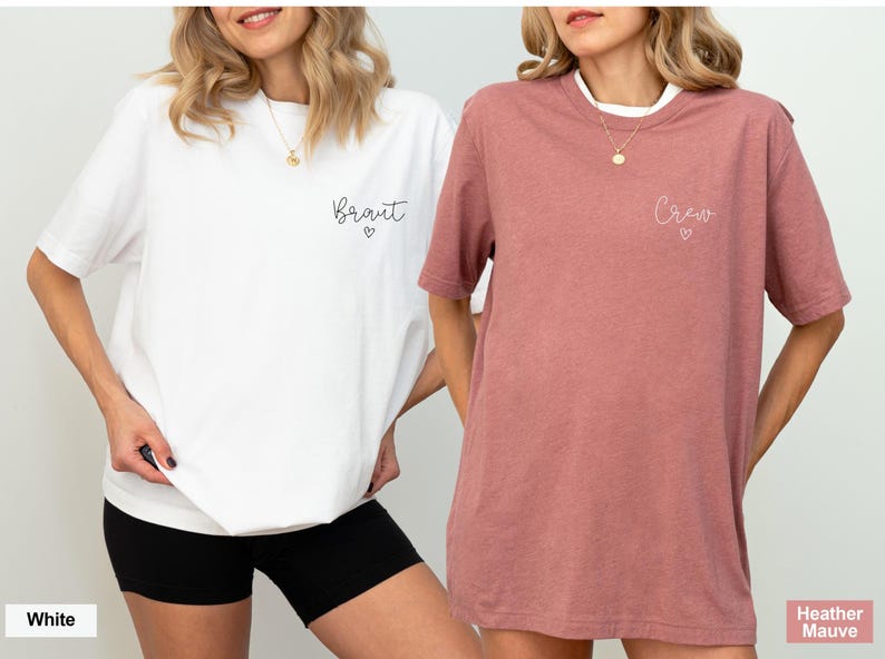 May include: Two women wearing matching t-shirts. One shirt is white with the word "Braut" and a heart, the other is heather mauve with "Crew" and a heart. Both shirts are short-sleeved.