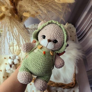 Un orsacchiotto fatto a mano, un morbido peluche lavorato all'uncinetto, è un regalo unico per un baby shower o come decorazione per la cameretta di un bambino.