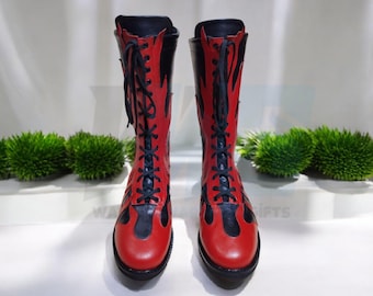 May include: A pair of red and black leather boots with a flame design. The boots have black laces and are tied up.