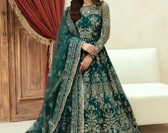 May include: A teal green maxi dress with intricate gold embroidery and sequins. The dress has a long sleeve and a round neckline. The dress is paired with a matching sheer dupatta.