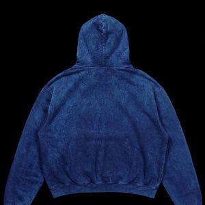 Puede incluir: Una sudadera con capucha azul con lavado &aacute;cido, capucha con cord&oacute;n y bolsillo de canguro. La sudadera tiene un ajuste relajado y est&aacute; hecha de un material suave y c&oacute;modo. La sudadera con capucha es una prenda vers&aacute;til para uso casual.