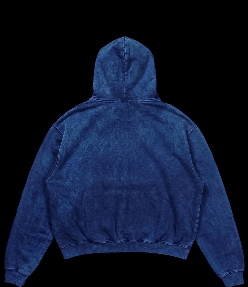 Puede incluir: Una sudadera con capucha azul con lavado &aacute;cido, capucha con cord&oacute;n y bolsillo de canguro. La sudadera tiene un ajuste relajado y est&aacute; hecha de un material suave y c&oacute;modo. La sudadera con capucha es una prenda vers&aacute;til para uso casual.