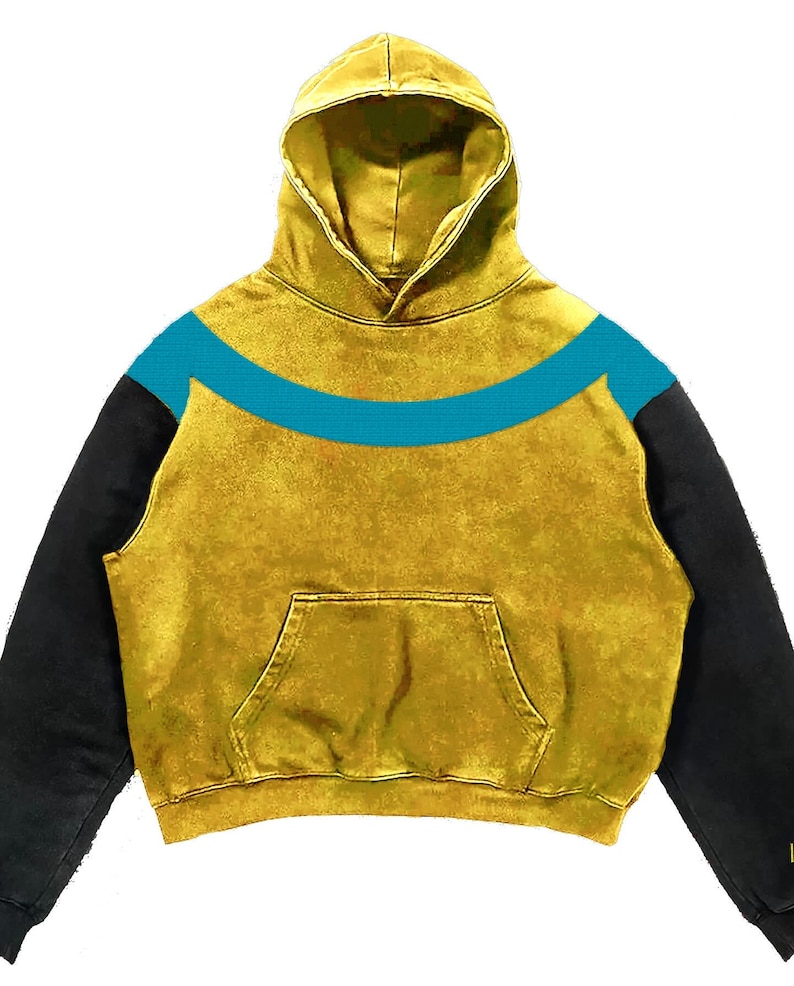 May include: Mustard yellow hoodie with a teal blue curved stripe across the chest. The hoodie has black sleeves and a front pocket. The hood is lined with the same mustard yellow material. The fabric has a textured, worn appearance.