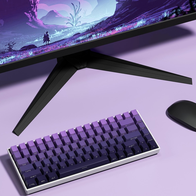 Peut inclure: Un clavier compact &agrave; cadre blanc avec des touches violettes d&eacute;grad&eacute;es est plac&eacute; sous un &eacute;cran d'ordinateur noir. Une souris noire est &agrave; droite. L'&eacute;cran affiche un paysage aux tons violets et bleus.
