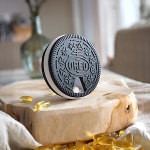 Organiseur de pilules Fidget - Trousse hebdomadaire de style Oreo avec 7 compartiments | Pilulier de voyage amusant, options de texte personnalisées, version mini porte-clés