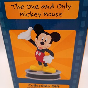 Puede incluir: Caja de regalo coleccionable con Mickey Mouse. La caja tiene un fondo azul con un panel naranja que muestra a Mickey Mouse con su atuendo cl&aacute;sico. El texto "The One and Only Mickey Mouse" est&aacute; encima de la imagen.