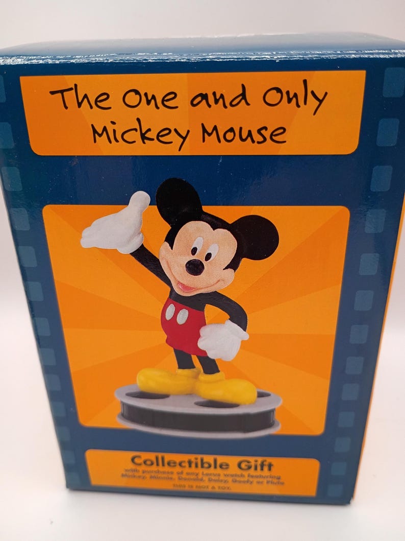 Puede incluir: Caja de regalo coleccionable con Mickey Mouse. La caja tiene un fondo azul con un panel naranja que muestra a Mickey Mouse con su atuendo cl&aacute;sico. El texto "The One and Only Mickey Mouse" est&aacute; encima de la imagen.