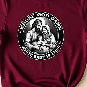 May include: Maroon t-shirt featuring a black and white graphic of a religious scene with the text "Whose God Damn White Baby Is This?". The shirt is styled with rolled-up sleeves and a knot at the bottom.
