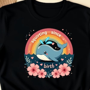 May include: Black t-shirt with a rainbow and a cartoon whale with the text "squirting since birth".