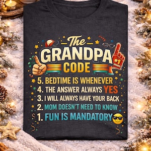 May include: Dark gray heather t-shirt with "The Grandpa Code" in colorful text. The design includes a thumbs-up, a foam finger, and the phrases: "Bedtime is whenever," "The answer always YES," and "Fun is mandatory."