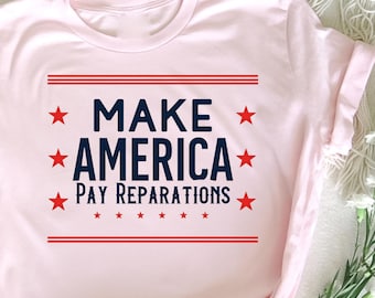 Può includere: Maglietta rosa con il testo "Make America Pay Reparations" in lettere blu con stelle rosse.