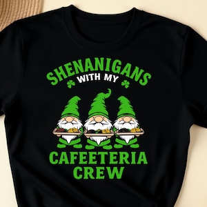 May include: Black t-shirt with a green graphic of three gnomes holding trays of food. The text "Shenanigans with my Cafeteria Crew" is printed on the shirt.