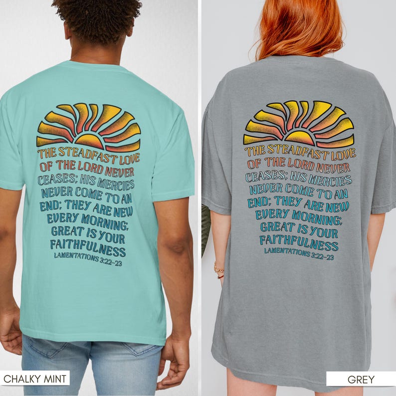 Pu&ograve; includere: Due t-shirt con una grafica di un sole e il testo "L'amore costante del Signore non cessa mai: Le sue misericordie non hanno mai fine: Sono nuove ogni mattina. Grande &egrave; la tua fedelt&agrave;. Lamentazioni 3:22-23". La t-shirt a sinistra &egrave; di colore azzurro chiaro e la t-shirt a destra &egrave; di colore grigio.