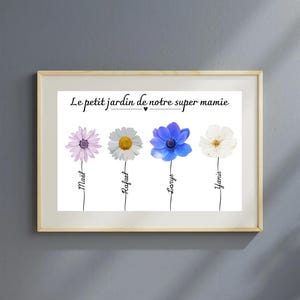 May include: A white framed print with the text "Le petit jardin de notre super mamie" and a heart symbol. Four flowers with names written underneath: Maël, Raphaël, Léo, Yanis.