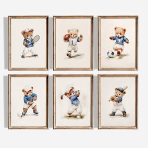 May include: Set of six framed watercolor prints featuring teddy bears engaged in various sports. The bears are depicted playing tennis, football, soccer, hockey, golf, and baseball. Each bear is wearing sports attire in blue and white.
