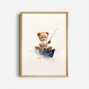 Puede incluir: Una ilustración de acuarela de un oso de peluche con una camisa blanca y un mono azul, sentado en una canoa azul y pescando con una caña. La canoa flota en un cuerpo de agua azul claro.