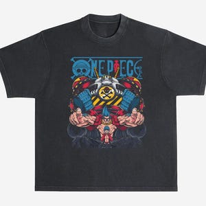 May include: Dark gray t-shirt featuring a colorful graphic from the anime series "One Piece." The design includes the series' logo and a detailed illustration of a character with blue hair and muscular arms. The shirt has a vintage, worn look.