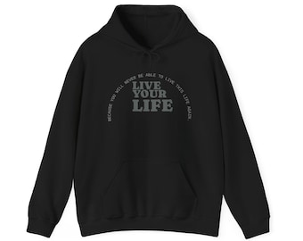May include: Black hooded sweatshirt with a drawstring and a front pocket. The front displays the text "LIVE YOUR LIFE" in a grey, arched font, with additional text above and below the main phrase.
