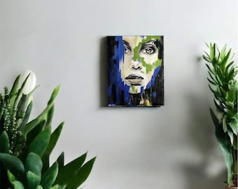 May include: Abstract painting of a woman's face with blue, green, and black paint strokes. The woman's eyes are closed and her lips are slightly parted.