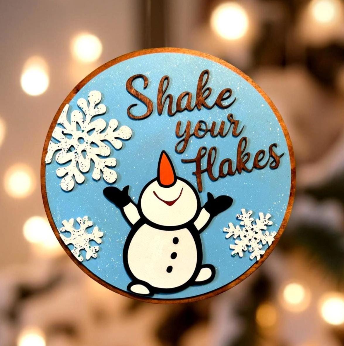 Shake Your Flakes Winter Sign – 14” Round Wooden Snowman Decor – Layered Snowflake Cutouts – Funny Holiday Door Hanger or Gift