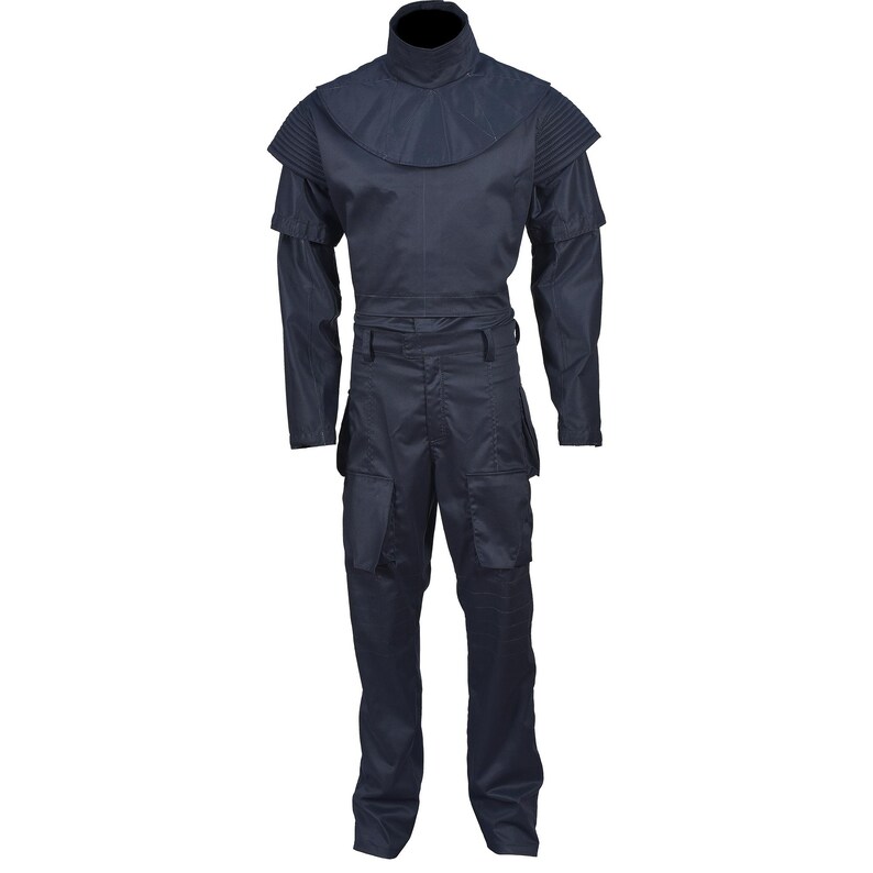 Puede incluir: Un mono azul oscuro con cuello alto y cintur&oacute;n. El mono tiene mangas largas y bolsillos cargo en las piernas.