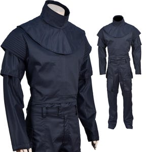 Puede incluir: Un mono azul oscuro con cuello alto y mangas largas. El mono tiene un cintur&oacute;n y bolsillos cargo.